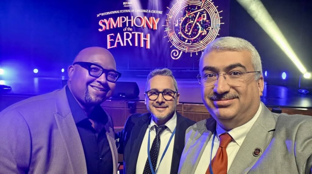 Atlantic Institute guests posing in front of the Symphony of the Earth stage sign