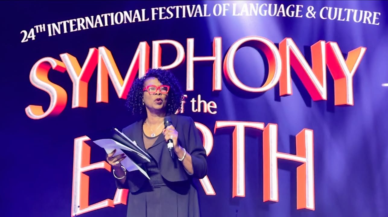 Cassandra A. Henderson serving as Master of Ceremonies on stage at the 24th International Festival of Language and Culture Symphony of the Earth