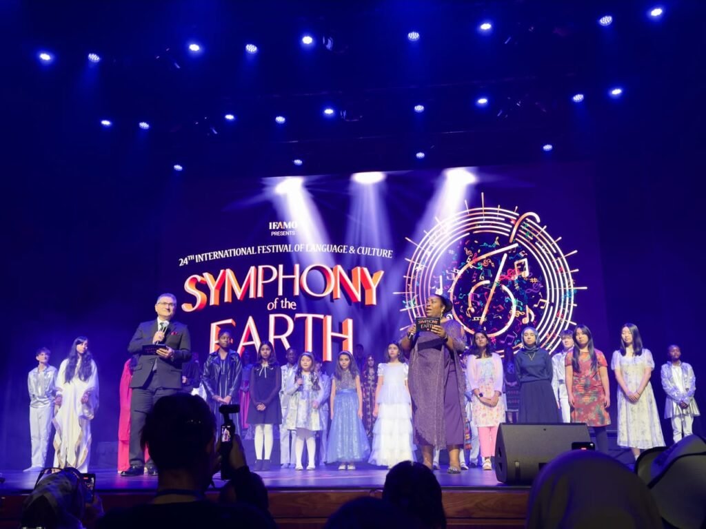 Atlantic Institute leaders smiling in front of the Symphony of the Earth stage backdrop